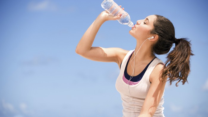 young teenager drinking water after exercise.